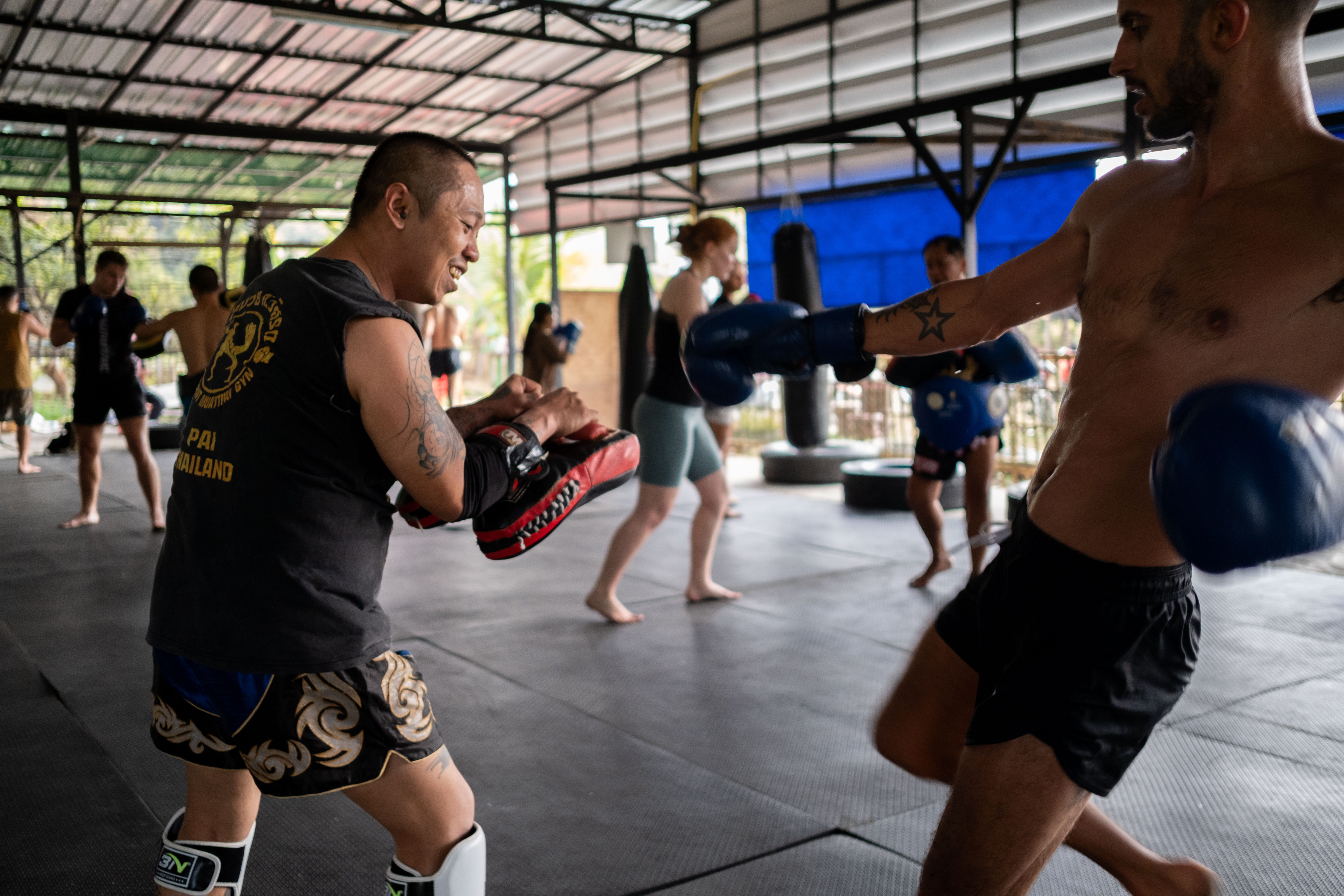 Muay Thai pad training - Students practicing authentic Thai boxing techniques at Muay Thai Pai in Pai, Thailand